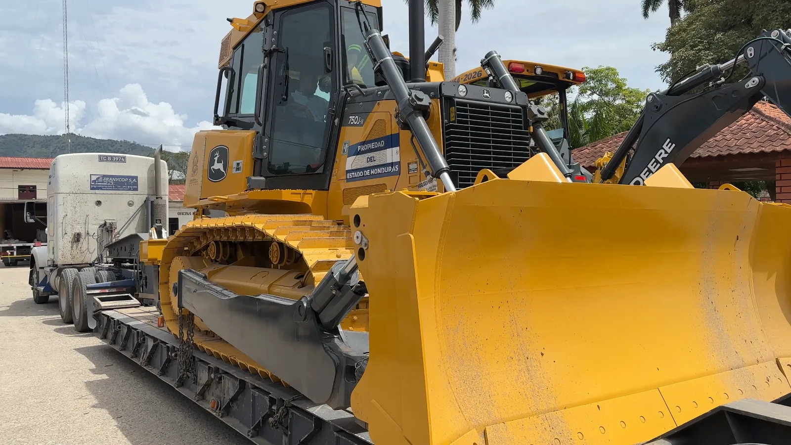 Tractor de oruga amarillo transportado sobre un remolque